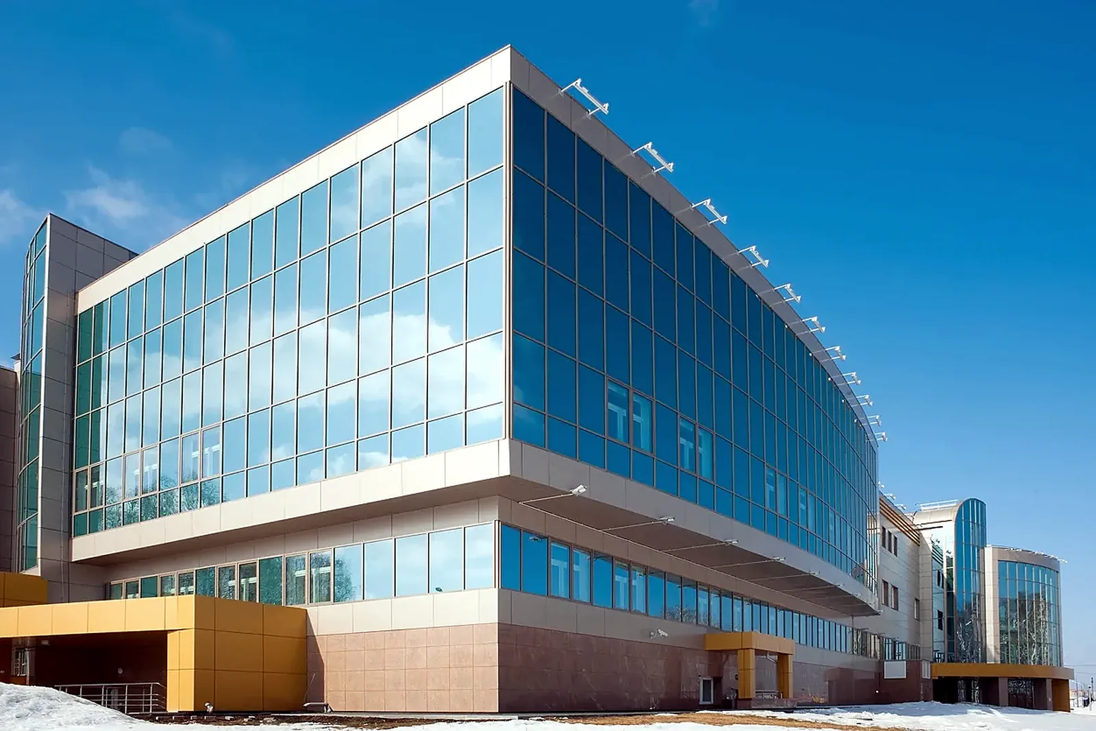 Modern multi-story commercial office building with glass curtain wall